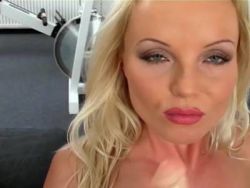 Frivole naturblonde Frau trainiert im Fitnesscenter und macht einen Strip für den Solosex